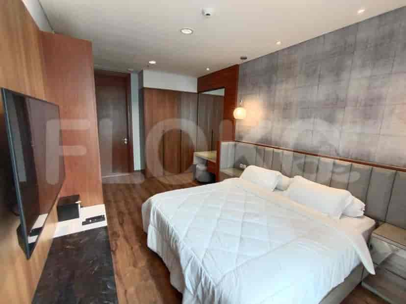Another view of a bedroom showing the bed, wardrobe, and TV.
