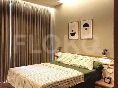A minimalist bedroom with a bed, artwork, and curtains.