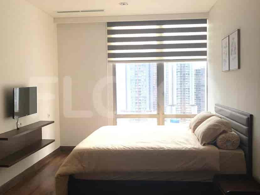 Bedroom with a bed, a TV, and a window.