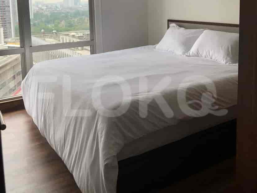 Kamar tidur dengan tempat tidur besar dan jendela yang menghadap ke kota.
