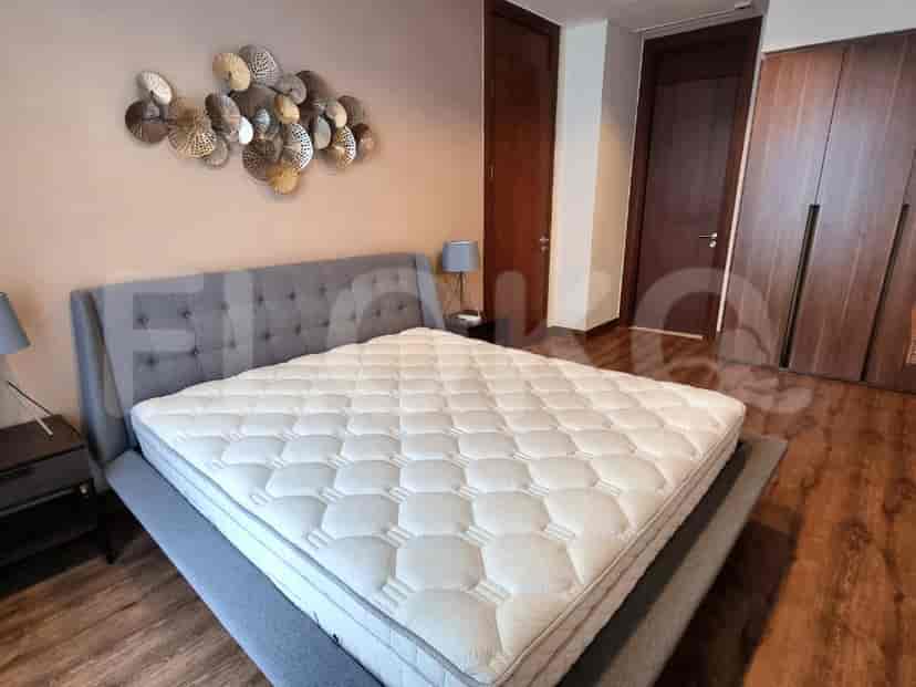 A modern bedroom with a grey bed, side tables, and wall art.