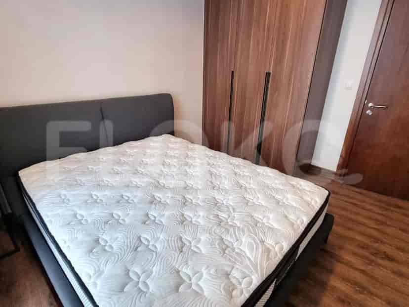 A bedroom with a double bed and wooden closet.