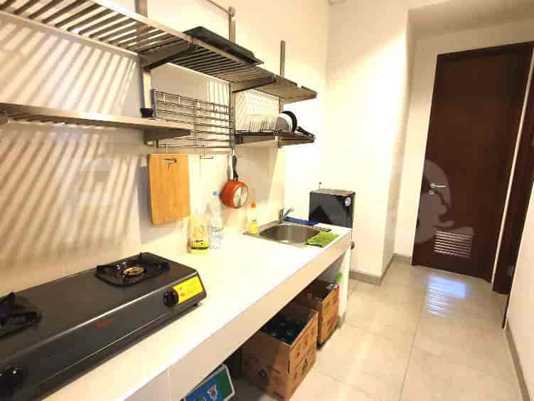 Compact kitchen area with stainless steel appliances and storage.