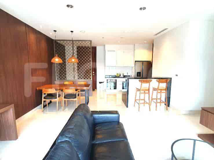 Bright living room featuring a kitchen, dining area, and leather sofa.