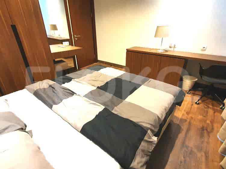 Bedroom with wooden flooring, bed, desk and closet space.