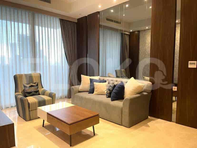 Living room with a grey sofa, striped armchair, coffee table, and large window.