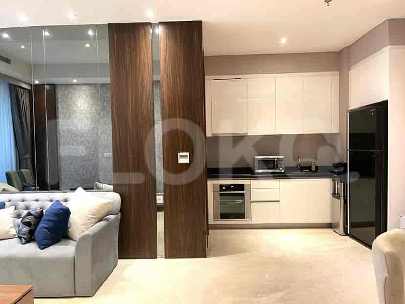 Kitchen with white cabinets and a stainless steel refrigerator, adjacent to the living room.