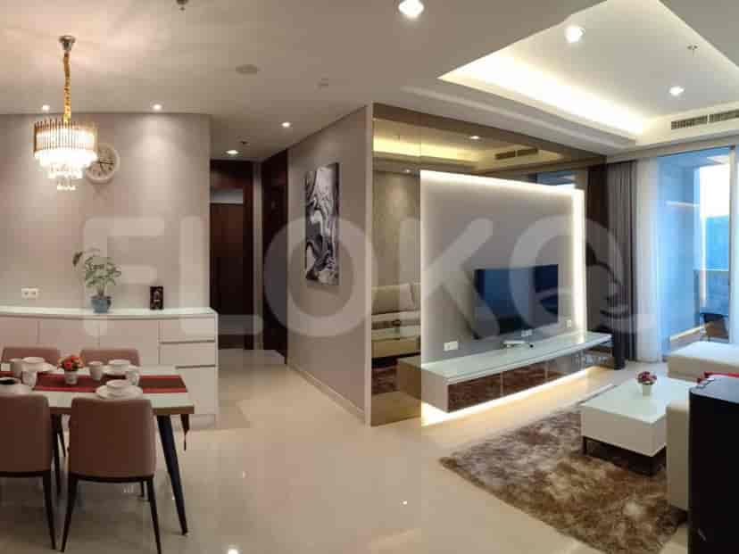 Open-plan living and dining area with a modern chandelier and city views.