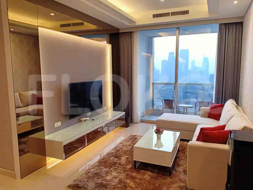 A modern living room with a grey L-shaped sofa, a wall-mounted TV, and a city view.