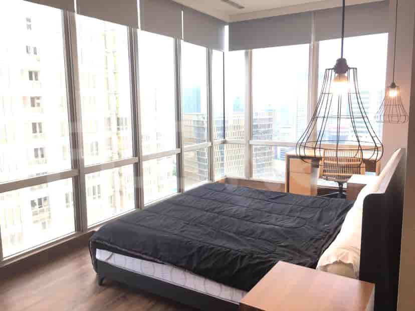 A spacious master bedroom with a large bed and a panoramic city view.