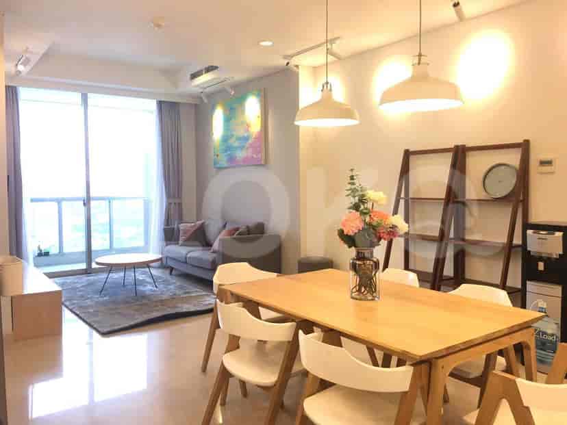 Dining area with a wooden table and chairs, pendant lights, and an adjacent living space.