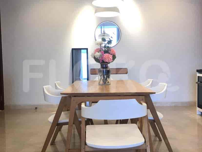 Dining room setup with wooden table, chairs, a vase of flowers, and a mirror.