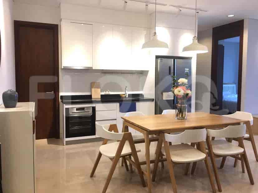 Open kitchen design with dining table, white cabinets, and modern appliances.
