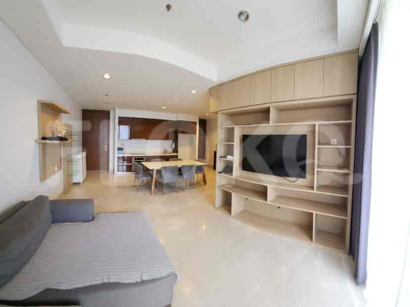 Open-plan living room with a sofa, entertainment unit, and dining area.