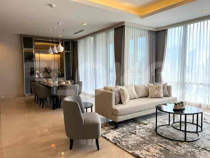 A combined living and dining area with a beige sofa, round glass coffee table, dining table, and floor-to-ceiling windows.