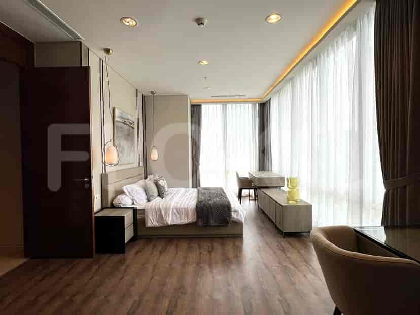 Spacious master bedroom with a bed, nightstands, desk and a large window.