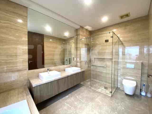 A modern bathroom featuring a walk-in shower and dual sinks.