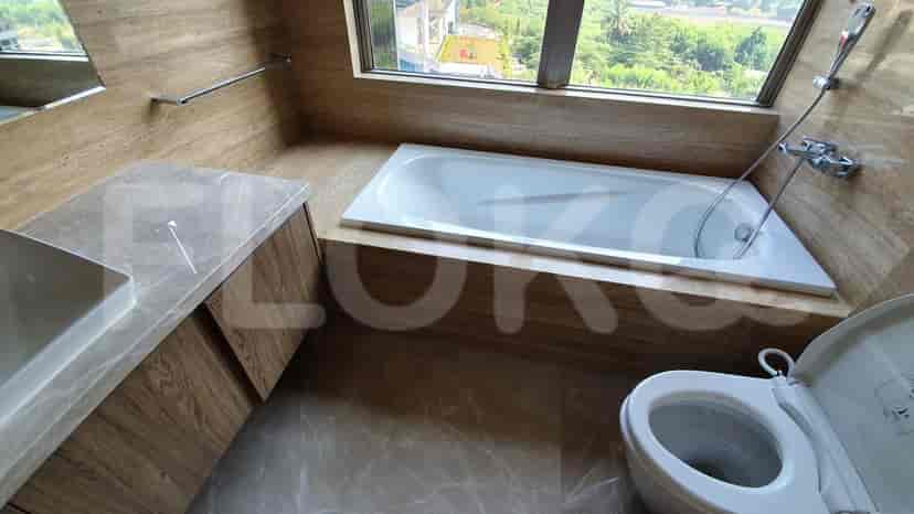 Kamar mandi mewah yang menampilkan bathtub, wastafel marmer, dan toilet.