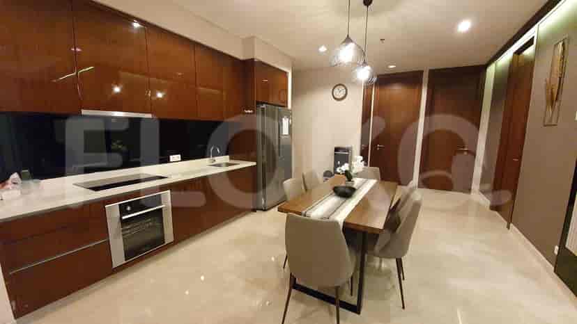 Dapur dan ruang makan modern yang menampilkan lemari kayu, kompor listrik, dan meja makan.