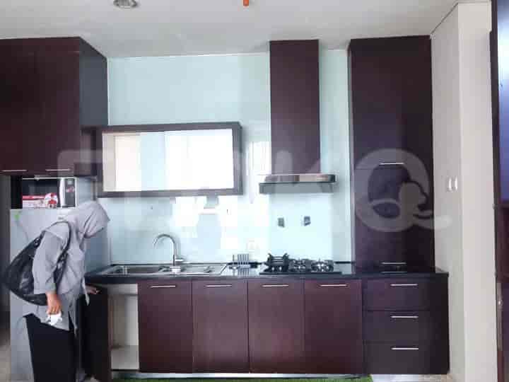 Another view of the kitchen with a woman in the background.