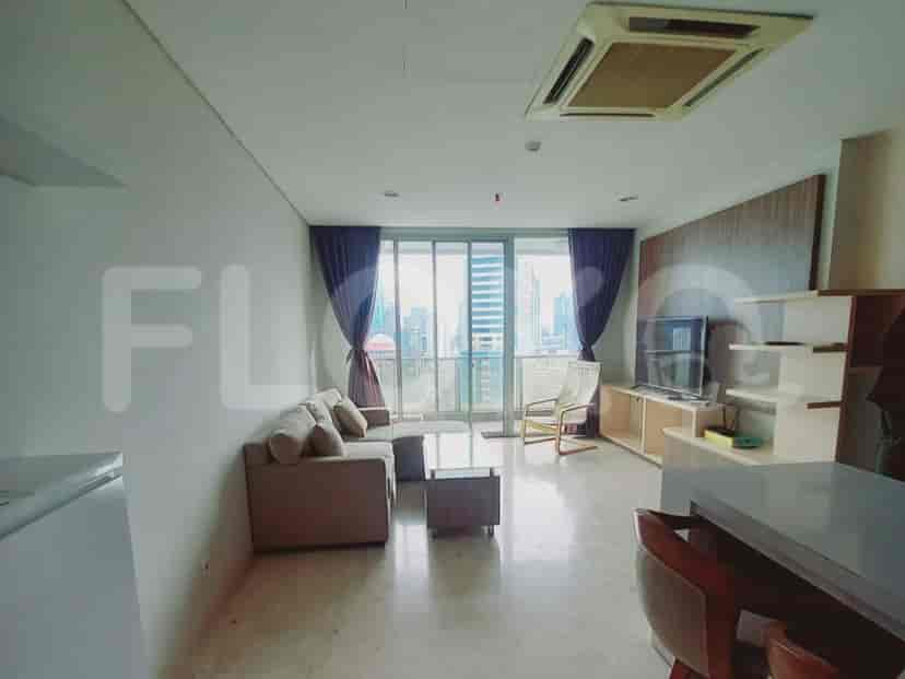 Spacious living room with sofa, smart TV, and large windows with city views.