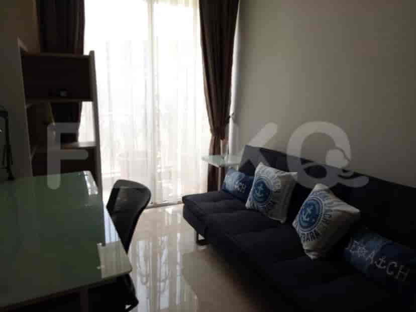 Living room with a dark blue sofa, dining table, and a view of the balcony.