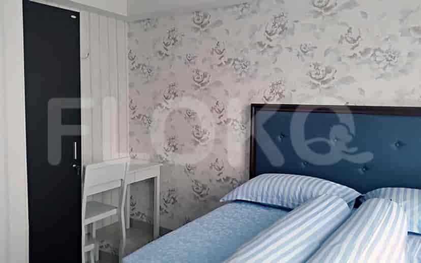 A bedroom with floral wallpaper, a bed, a desk, and a wardrobe.