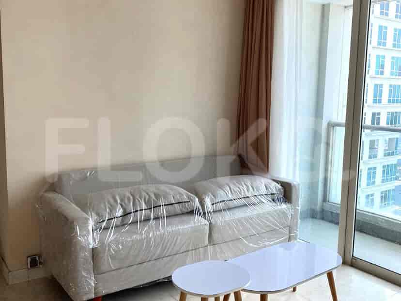 A living room with a covered sofa and a small white coffee table.