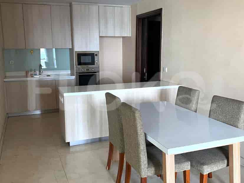 A kitchen with white cabinets, dining table and chairs.