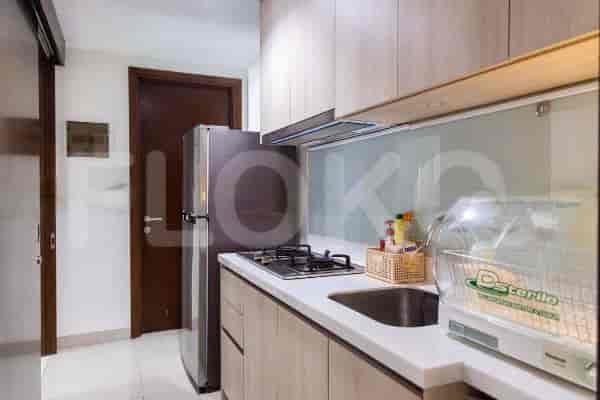 Compact kitchen with a refrigerator, gas stove, and stainless steel appliances.