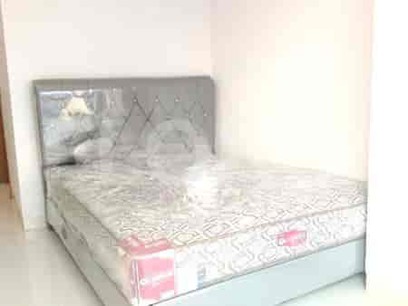 A bedroom with a queen bed and ample natural light.