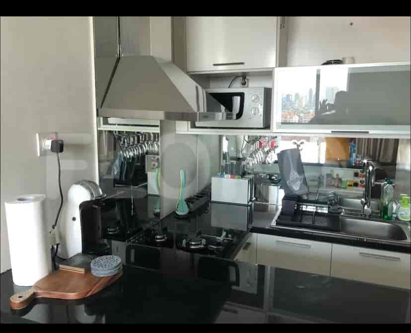 A modern kitchen featuring a sleek design, stainless steel appliances, and a mirrored backsplash.