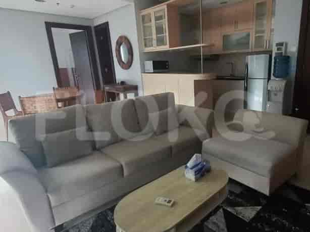 Living room with a sofa, a coffee table, and a kitchen in the background.