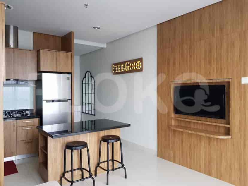 Modern kitchen and living area with a breakfast bar and a TV.