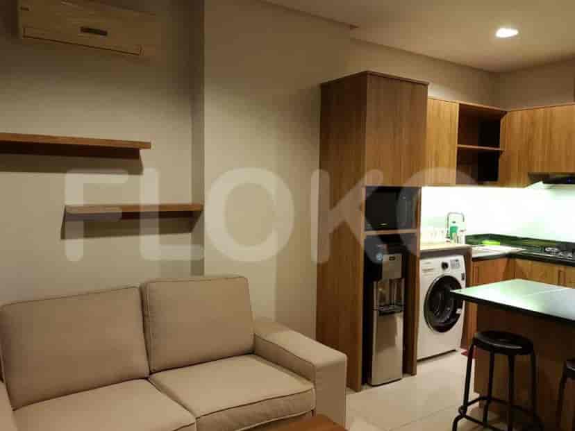 Modern living area with a sofa, kitchen, and water dispenser.