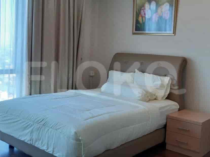 A cozy bedroom featuring a queen-sized bed, bedside table, and a large window offering natural light.