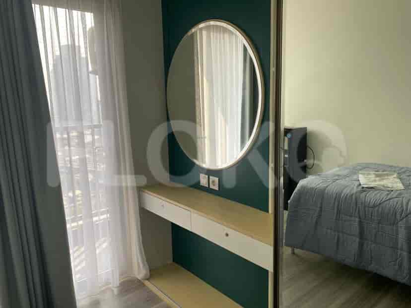 Kamar tidur dengan area rias dan sekilas tempat tidur.