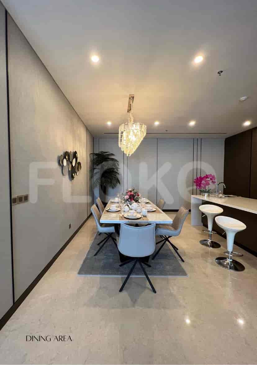Area makan yang elegan dengan meja, lampu gantung, dan tempat duduk.