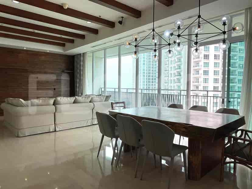 Living room with a large wooden dining table and city view.