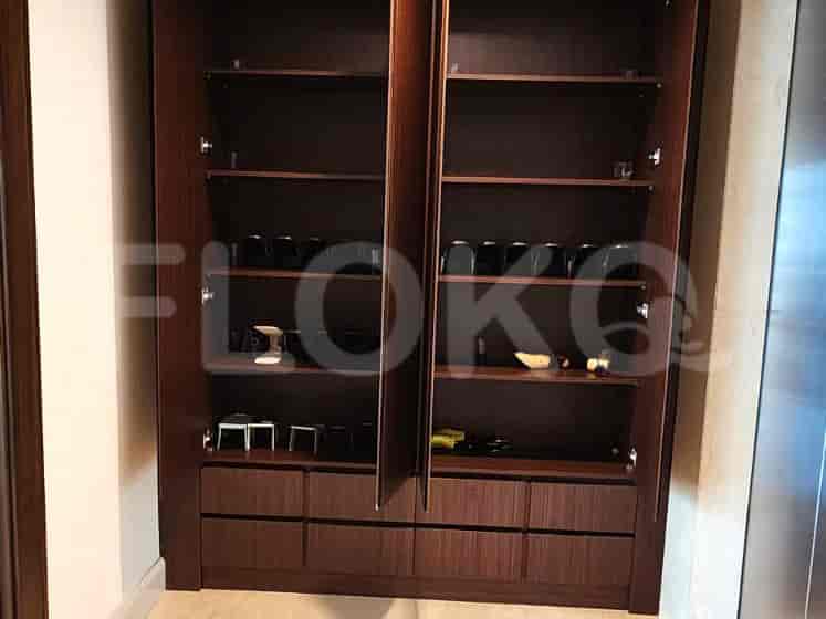 A built-in closet with open doors, revealing shelves and drawers with various items.