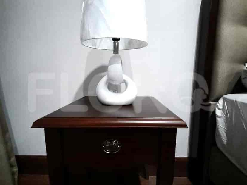 A detailed view of a nightstand with a lamp on it.