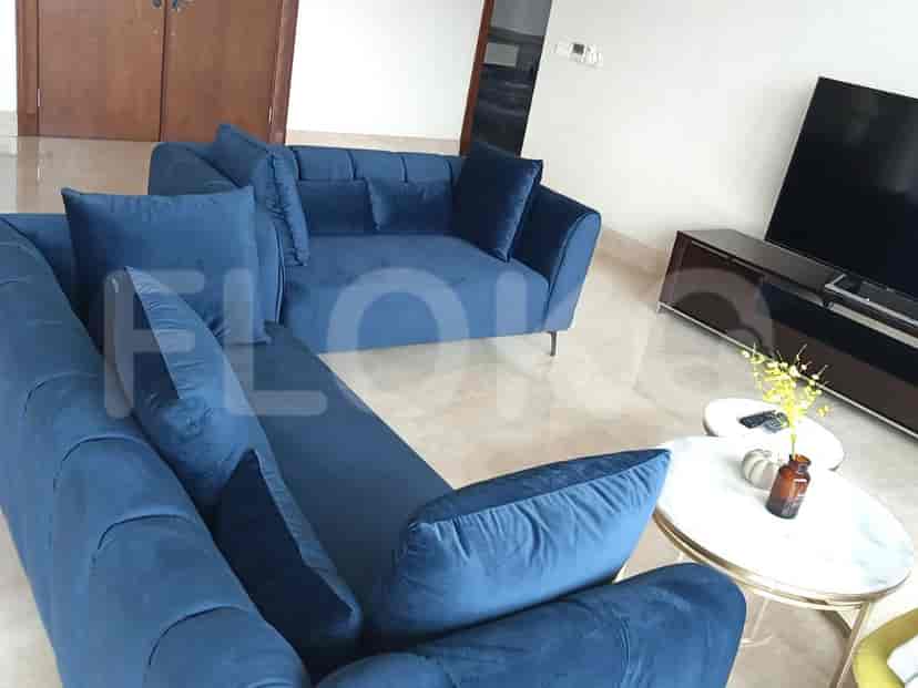 Living area featuring a blue velvet sectional sofa and modern decor.