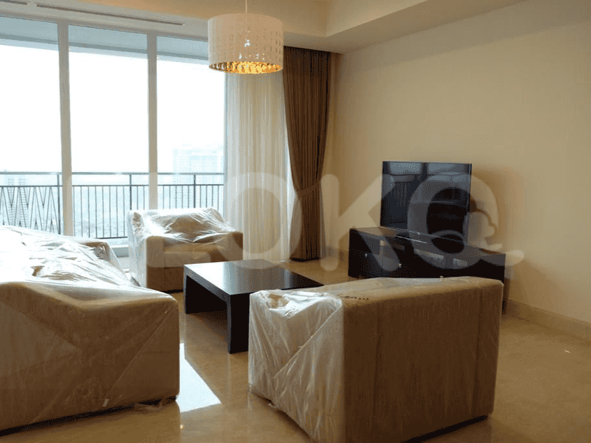 A modern living room with furniture wrapped in plastic.