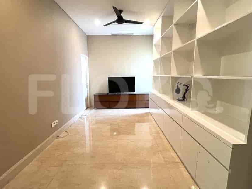 Living area with TV and shelving.