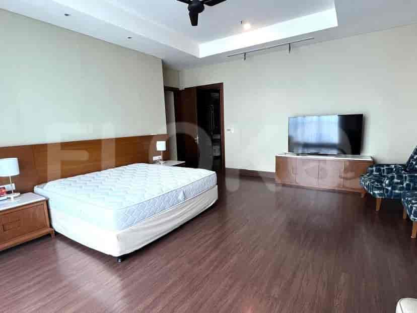 Large bedroom with bed, TV, and seating area.