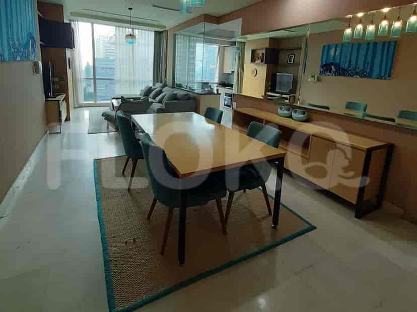 Dining area and living area with dining table, chairs, and artwork.