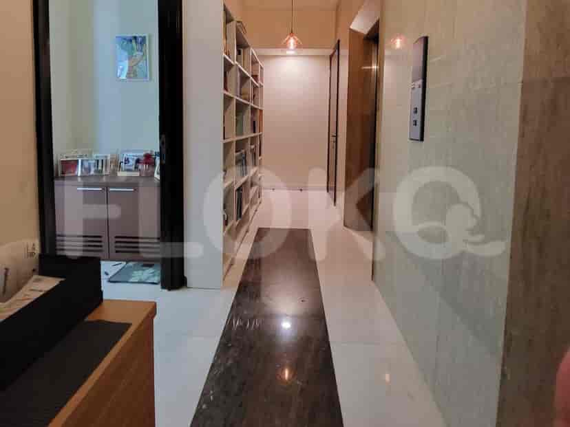 Hallway with built-in bookshelves and a door.