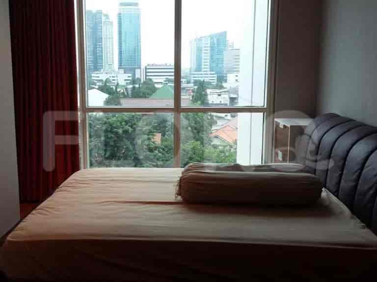 A bedroom with a large bed, window with city view, and neutral color scheme.