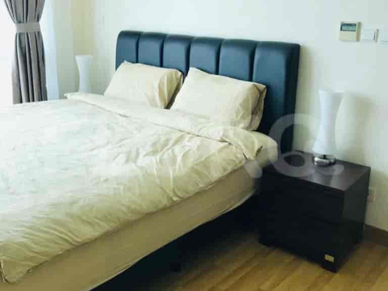 A well-lit bedroom with a large bed, nightstands, and bedside lamps.