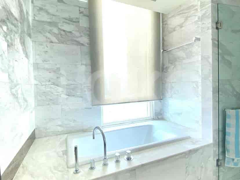 Bathroom with bathtub and marble finishes.